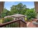 A view of the backyard with trees and a detached living space and a deck at 1535 Pathfinder Sw Way, Lilburn, GA 30047