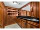 Charming bar area features wood paneling, cabinets, shelving, a sink, and a mirror at 1535 Pathfinder Sw Way, Lilburn, GA 30047