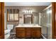 Bathroom with double vanity, toilet, large mirror with vanity lighting, and shower with glass doors at 1535 Pathfinder Sw Way, Lilburn, GA 30047