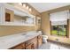 Bathroom featuring a large vanity with white countertop, toilet, and a window with a private view at 1535 Pathfinder Sw Way, Lilburn, GA 30047
