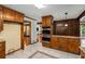 Kitchen featuring wood cabinets, granite countertops, double ovens, and tile floor at 1535 Pathfinder Sw Way, Lilburn, GA 30047