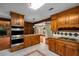 Spacious kitchen with stainless steel double ovens, wood cabinets, and granite countertops at 1535 Pathfinder Sw Way, Lilburn, GA 30047