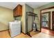 Well lit laundry room with ample storage space, washer, dryer, and folding rack with easy access to the porch at 1535 Pathfinder Sw Way, Lilburn, GA 30047