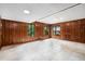 Spacious living room features wood-paneled walls, tile flooring, and multiple windows for ample light at 1535 Pathfinder Sw Way, Lilburn, GA 30047