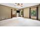 Spacious main bedroom with neutral carpet, ceiling fan, windows with views, and en suite bathroom at 1535 Pathfinder Sw Way, Lilburn, GA 30047