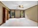 Spacious main bedroom with neutral carpet, ceiling fan, windows with views, and en suite bathroom at 1535 Pathfinder Sw Way, Lilburn, GA 30047