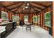 Cozy sunroom with wood paneling, large windows, dining table, and a small kitchen area at 1535 Pathfinder Sw Way, Lilburn, GA 30047