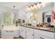 Bright bathroom featuring a double vanity with granite countertops, soaking tub, and a window for natural light at 2130 Hampton Se Trl, Conyers, GA 30013