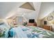 Bright attic bedroom features a sitting area, desk, and large television for relaxation at 2130 Hampton Se Trl, Conyers, GA 30013