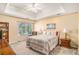 Bright Primary bedroom with a tray ceiling, a large window, and a cozy reading nook at 2130 Hampton Se Trl, Conyers, GA 30013