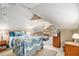 Well-lit attic bedroom with sitting area, dresser, and tropical themed bedding at 2130 Hampton Se Trl, Conyers, GA 30013