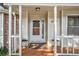 Inviting front porch with decorative columns, potted plants, and a patterned welcome mat leading to the front door at 2130 Hampton Se Trl, Conyers, GA 30013