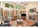 Bright living room featuring a brick fireplace, large windows offering outdoor views, and cozy seating arrangement at 2130 Hampton Se Trl, Conyers, GA 30013