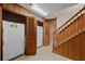 Hallway with fridges, wood paneling, tile flooring, and a staircase at 4116 River Cliff Chase Se, Marietta, GA 30067