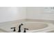 Bright bathroom featuring a large soaking tub, neutral tile, and updated fixtures at 3906 Laurens Ln, Snellville, GA 30039