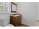 Powder room with granite countertop vanity and wood cabinets at 3906 Laurens Ln, Snellville, GA 30039