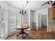 Sunlit breakfast nook with wood table, chandelier, tiled floors, and large windows with shutters at 3906 Laurens Ln, Snellville, GA 30039