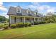 Charming brick home with a well-manicured lawn, a welcoming front porch, and dormer windows at 3906 Laurens Ln, Snellville, GA 30039