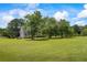 Expansive front yard with lush green lawn, mature trees, and a charming home with a welcoming porch at 3906 Laurens Ln, Snellville, GA 30039