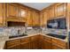 Stylish kitchen with granite countertops, tile backsplash, wooden cabinets and a sleek black cooktop at 3906 Laurens Ln, Snellville, GA 30039