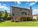 Expansive backyard with a large wooden deck, covered patio, and mature landscaping at 4249 Caveat Ct, Fairburn, GA 30213