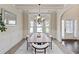 Bright dining room boasts modern chandelier, large windows, wainscoting, and is ready for entertaining at 4249 Caveat Ct, Fairburn, GA 30213