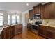 Open kitchen with granite counters, dark wood cabinets, and stainless steel appliances at 4249 Caveat Ct, Fairburn, GA 30213