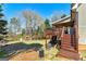 Backyard with stairs leading to an elevated back deck and a lush wooded area with a playhouse at 149 Crown Glen Way, Stockbridge, GA 30281