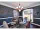 Formal dining room featuring a large window, sophisticated lighting, and elegant decor at 149 Crown Glen Way, Stockbridge, GA 30281