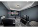 Home theater with screen showing a football game, comfortable seating, dim lighting, and sleek design for immersive viewing at 149 Crown Glen Way, Stockbridge, GA 30281