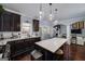 A well-appointed kitchen with dark cabinets, a large island, and seamless transition to other living spaces at 149 Crown Glen Way, Stockbridge, GA 30281