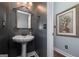 Charming powder room featuring a pedestal sink, decorative mirror, and elegant wall art, offering a stylish and functional space at 149 Crown Glen Way, Stockbridge, GA 30281