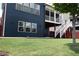 A spacious backyard featuring a well-manicured lawn and the home's blue siding with stairs to an upper level at 326 Still Pine Bnd, Smyrna, GA 30082
