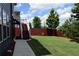 Spacious backyard with well-maintained lawn, red fencing, and stairs leading to an upper level at 326 Still Pine Bnd, Smyrna, GA 30082