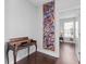 Hallway with dark wood flooring, decorative artwork, and view into another room at 326 Still Pine Bnd, Smyrna, GA 30082