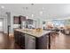 Open-concept kitchen with granite countertops, stainless appliances, island, and seamless flow to dining and living areas at 326 Still Pine Bnd, Smyrna, GA 30082
