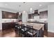 Spacious kitchen with granite countertops, dark wood cabinetry, an island with seating and pendant lighting at 326 Still Pine Bnd, Smyrna, GA 30082