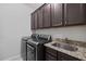 The Laundry room has upper storage cabinets, granite counters, and modern appliances at 326 Still Pine Bnd, Smyrna, GA 30082