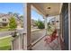 Inviting front porch with red metal chairs and white railings looking out onto the street and landscaped yard at 326 Still Pine Bnd, Smyrna, GA 30082