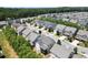 Sprawling aerial view of a residential neighborhood with rows of homes and a backdrop of lush greenery and mature trees at 4452 Thach Ave, Sugar Hill, GA 30518
