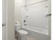Clean bathroom showcasing a tub-shower combo, a toilet, and neutral tile flooring at 4452 Thach Ave, Sugar Hill, GA 30518