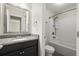 Well-lit bathroom featuring a granite countertop, dark vanity, and a shower-tub combo at 4452 Thach Ave, Sugar Hill, GA 30518