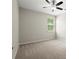 Cozy bedroom with neutral tones, ceiling fan, and a window offering natural light and neighborhood view at 4452 Thach Ave, Sugar Hill, GA 30518