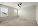 Bedroom with carpet flooring, two windows offering natural light, and a ceiling fan at 4452 Thach Ave, Sugar Hill, GA 30518