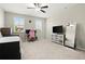 Spacious bedroom with two windows, carpet flooring, study setup with a pink chair and TV area at 4452 Thach Ave, Sugar Hill, GA 30518