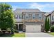 Charming two-story home featuring a stone and siding facade, a two-car garage, and a well-manicured lawn at 4452 Thach Ave, Sugar Hill, GA 30518