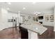 Open concept kitchen with island, stainless steel appliances, and view to the living area at 4452 Thach Ave, Sugar Hill, GA 30518