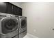 A modern laundry room features a stacked washer and dryer, and overhead storage at 4452 Thach Ave, Sugar Hill, GA 30518