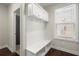 Mudroom with built-in bench, storage, and convenient access to an adjacent bathroom at 4452 Thach Ave, Sugar Hill, GA 30518