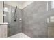 Contemporary shower with gray tiling and a glass door, showcasing modern fixtures and a clean design at 4452 Thach Ave, Sugar Hill, GA 30518